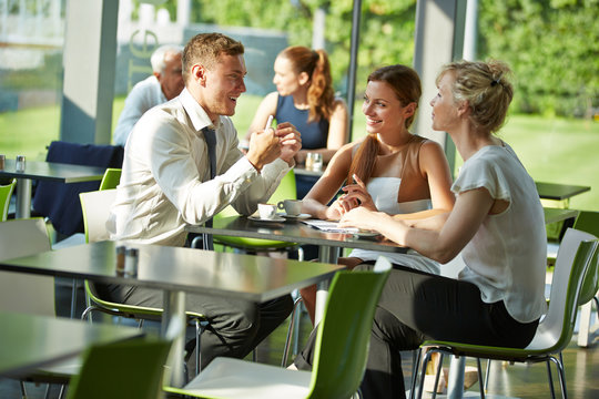 Gesch&auml;ftsleute sitzen f&uuml;r Besprechung am Tisch