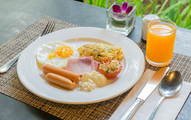 Plate with fried eggs, bacon and chicken sausage