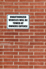 Vertical composition of a sign warning that unauthorized vehicles will be towed