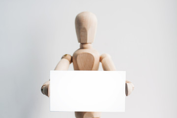 Wooden mannequin with a business card. 