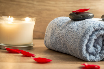 Luxurious spa setting with a rolled blue towel, romantic candle