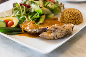 pork steak in white plate with salad