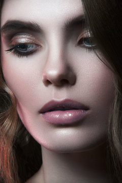 Close up beauty portrait of young girl with big green eyes, pouty lips with natural lipstick and gap in teeth looking at you and breathing with open lips on black background
