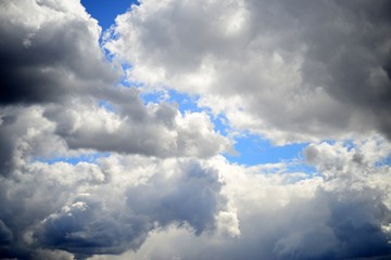 Obraz premium Big fluffy white and dark clouds in the blue sky