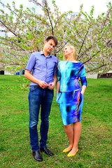 Fototapeta premium Young couple in the sakura's garden in park