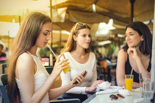 Three girls sitting at a cafe