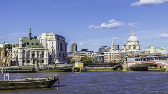 Time lapse view of St Paul cathedral and Blackfriars bridge in London in a late afternoon with blue sky and clouds, boats cruising on the river Thames