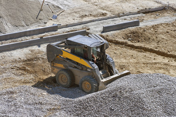 loader small bulldozer moving breakstone at construction area