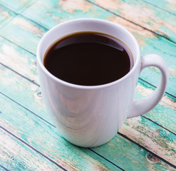 A mug of coffee drink over rustic weathered wooden background