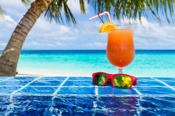 cocktail and sunglasses, on the edge of infinity pool