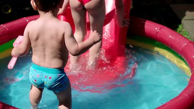 Children splashing and playing in swimming pool. Shoot on Digital Cinema Camera in slow motion-ProRes 422 codec.
