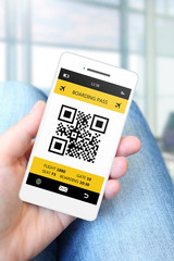 hand holding mobile phone with boarding pass on airport
