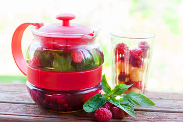 Teapot with mint and red raspberries