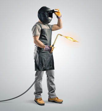 worker welder in a protective mask with gas welding machine