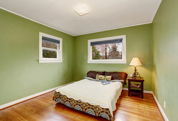 Boho themed bedroom with green walls, and hardwood floor.