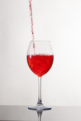 Calice di vino, su piano riflettente e sfondo bianco