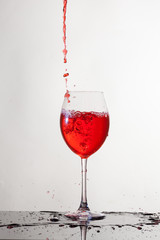 Calice di vino, su piano riflettente e sfondo bianco