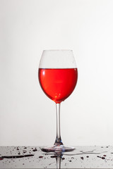 Calice di vino, su piano riflettente e sfondo bianco