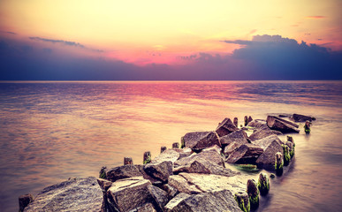 Plakaty  Fioletowy zachód słońca na plaży, spokojny krajobraz morza.