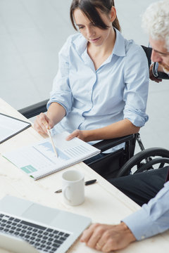 Woman on wheelchair working at desk