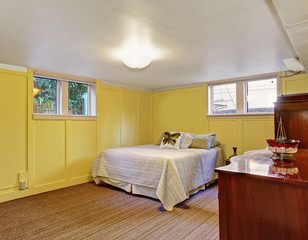 Cozy bedroom with yelow walls and windows.