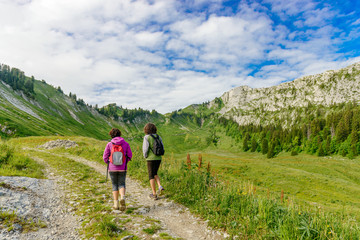 Fototapeta premium Two hikers women walking in the mountains