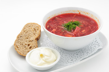 Russian traditional beetroot soup with bread and sour cream isolated on white.