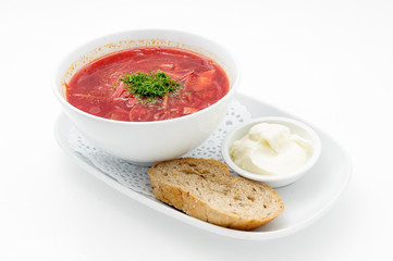 Russian traditional beetroot soup with bread and sour cream isolated on white.