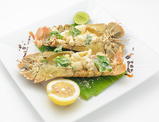 Steamed stone lobster with lemon and lime isolated on white.