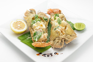 Steamed stone lobster with lemon and lime isolated on white.