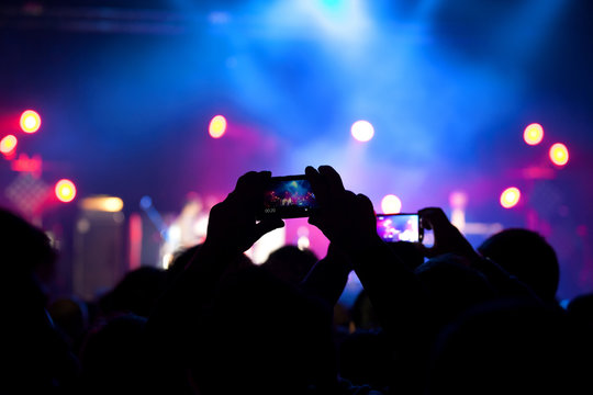 People at rock concert taking photos with cell phone