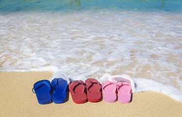 Fototapeta na wymiar Colorful flip flops on the sandy beach