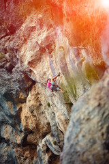 Rock climber climbing up a cliff