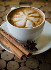 a cup of latte art on wooden background
