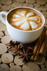 a cup of latte art on wooden background