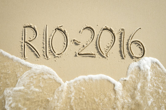 Simple Rio 2016 message handwritten in clean numbers on smooth sand beach in Rio de Janeiro Brazil