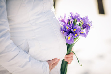 A pregnant mother with flowers holding her belly