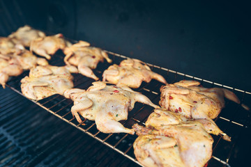 Seasoned chickens roasting on a grill