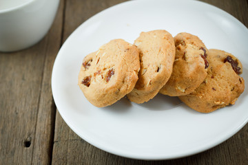 Chocolate chip cookies on white disk on wooden table