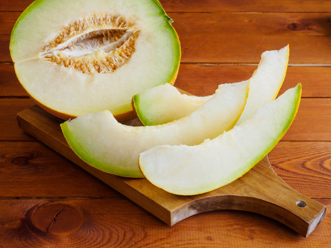 Slices of fresh and sweet melon on wooden board