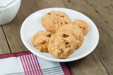 Chocolate chip cookies on white disk on wooden table
