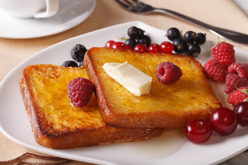 Two French toast with honey and berries close-up. Horizontal
