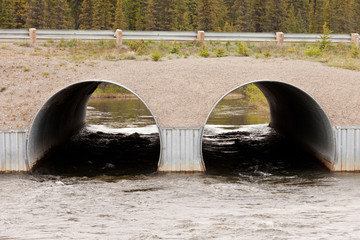 Twin culvert tunnel road bridge crossing wild river