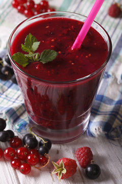Delicious smoothie with raspberries and currants closeup. Vertical

