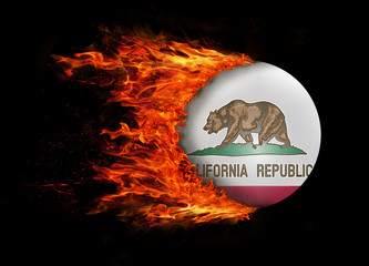 US state flag with a trail of fire - California