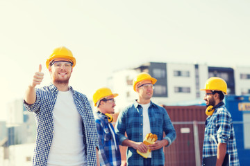 group of smiling builders in hardhats outdoors