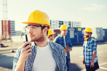 group of builders in hardhats with radio