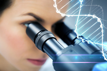 close up of scientist looking to microscope in lab