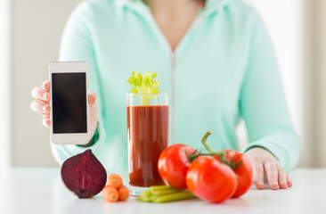 close up of woman with smartphone and vegetables