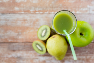 close up of fresh green juice and fruits on table